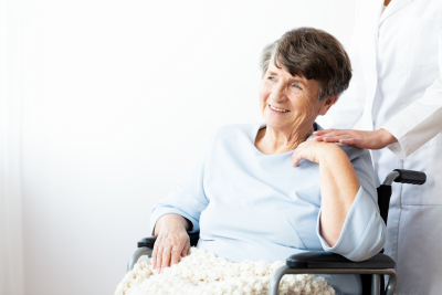smiling senior woman on a wheelchair with her caregiver